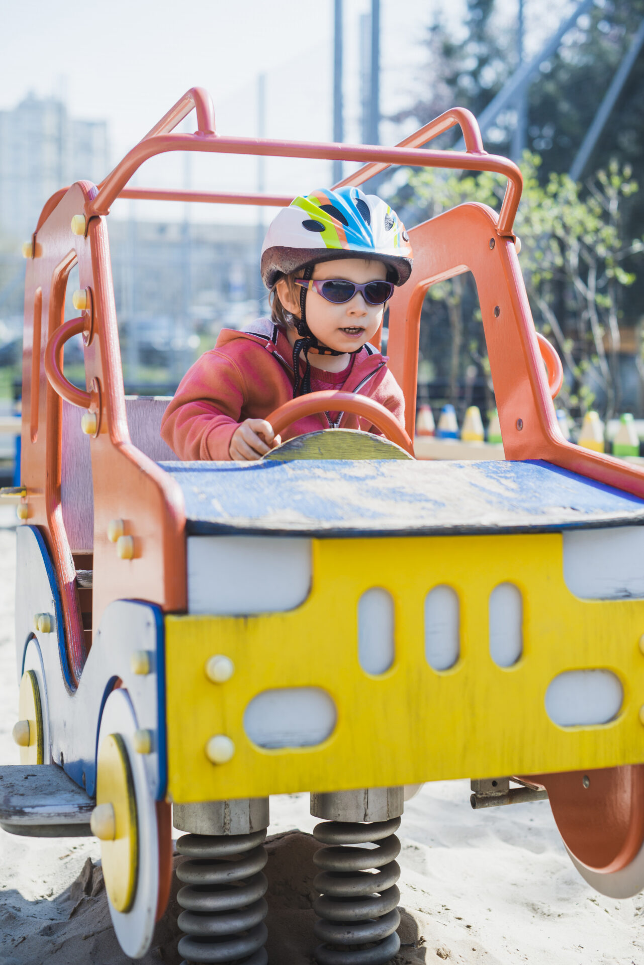 Un enfant portant un casque de vélo joue sur une aire de jeu
