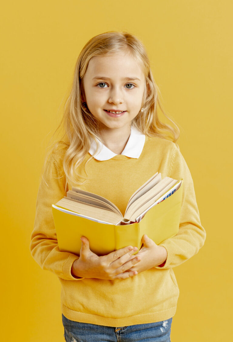 une jeune fille blonde tient un livre ouvert